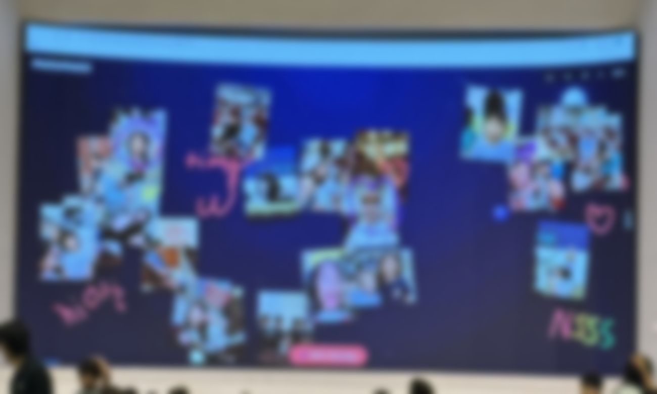A big screen at a church event filling with photos and drawings sent in from families' phones in real time